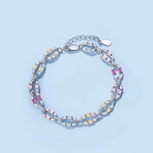 Macro shot of silver tennis bracelet with colorful gemstones and micro-pave crystals