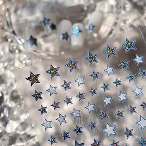 Macro shot of blue star nail stickers with holographic laser glitter and silver accents