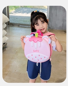 Detail of pink strawberry-shaped hard shell kids backpack with lucky text and green leaf detail