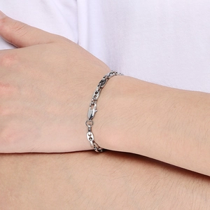 Gros plan d'un bracelet chaîne nez de cochon minimaliste en acier inoxydable au poignet