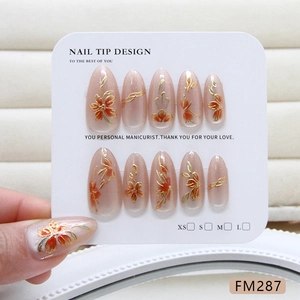 Handmade almond press-on nails with red cat-eye floral patterns and gold enamel finish