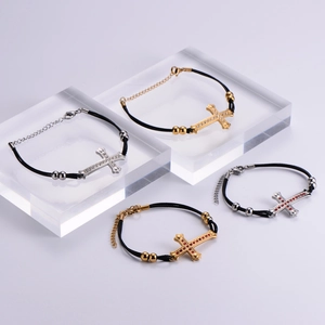 Detail of cross charm bracelets with red and clear crystals in gold and silver finishes