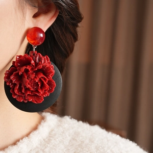 Boucles d'oreilles vintage en résine fleurie rouge et noire portées par un mannequin
