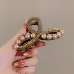 Dettaglio molletta per capelli marrone con perle champagne e strass scintillanti