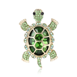 Elegant gold turtle brooch with green faceted crystals and sparkling rhinestones