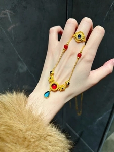 Detailed close-up of a vintage-style gold bracelet with blue resin stones and star charms