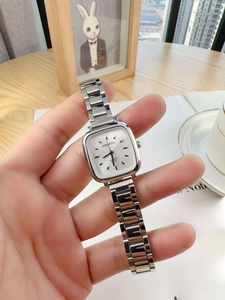 Close-up of a silver square women's watch with a minimalist dial and polished metal strap