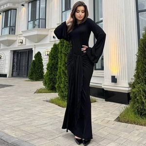 Détail du nœud à la taille et des manches cloches sur une robe maxi noire ajustée