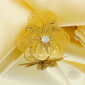 Golden 3D multi-layer flower ring with center crystal on yellow silk background