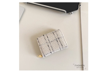 Top view of a tweed square card holder with black checkered lines and gold zipper