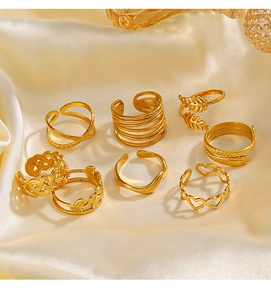 Detailed set of 8 pieces 18K gold-plated adjustable rings on beige silk background