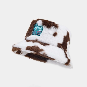 Detail of plush cow print bucket hat with embroidered Chill OUT patch and soft texture