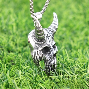 Macro detail van vintage punk geitenschedel hanger met hoorns en kruis aan metalen ketting