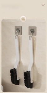 Detail view of long-handled gap cleaning brushes with hook holes for wall storage