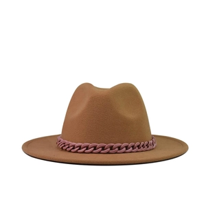 Détail d'un chapeau en laine camel orné d'une chaîne rose tendance sur le bord
