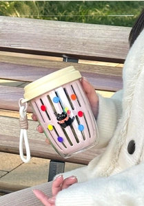 Close-up of portable pink double-layer fruit cup with strainer and cute cat pattern