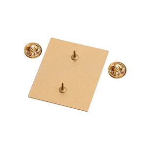 Detail of the golden metal badge back with double pins and two butterfly clutch fasteners