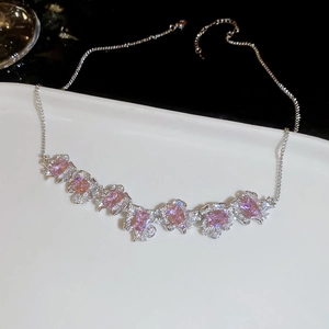 Detail of flower pendant necklace with pink zircons on a white ceramic plate