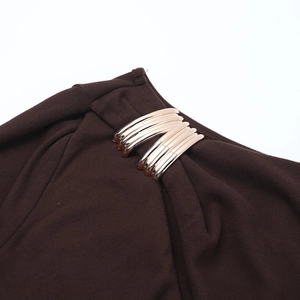 Détail de la boucle en métal doré et des plis sur la robe en maille marron