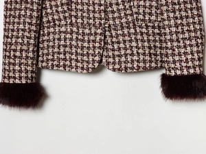 Close-up of burgundy tweed blazer featuring luxurious faux fur cuffs and textured fabric