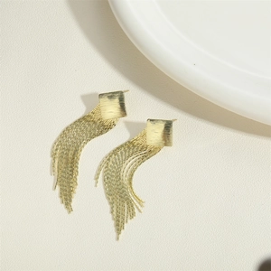 Elegant gold tassel earrings with brushed square studs and fine metal chains on beige background