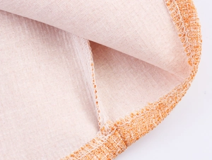 Détail du tissu en tweed orange avec couture fine et doublure intérieure rose tendre