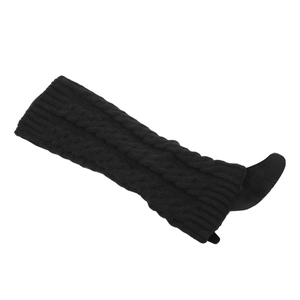 Detailed view of thick cable knit texture and ribbed cuff on black leg warmers