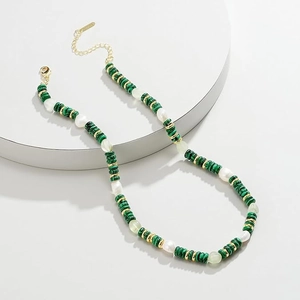 Detail of bohemian necklace featuring green malachite beads and irregular white pearls