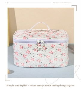Detail of floral quilted makeup bag with star-shaped zipper and top handle