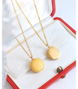 Macro shot of gold brushed geometric pendants in a vintage velvet jewelry box