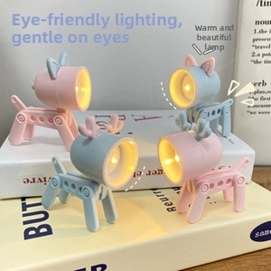 Mini LED night lights in dog and deer shapes with adjustable limbs on stack of books