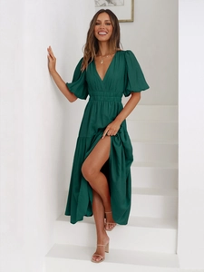 Detail of deep V-neck and puff sleeves on a dark green high-waist summer maxi dress