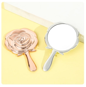 Detail of rose gold and silver flower shaped hand mirrors with polished metal handles