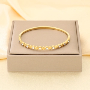 Dettaglio di un bracciale in acciaio inossidabile placcato oro 18K con zirconi bianchi.