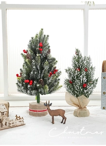 Miniature snow-flocked Christmas trees with red berries and burlap base for desk decor