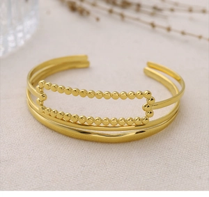 Detailed view of the 18K gold plated triple-layer open bangle with beaded rectangle charm