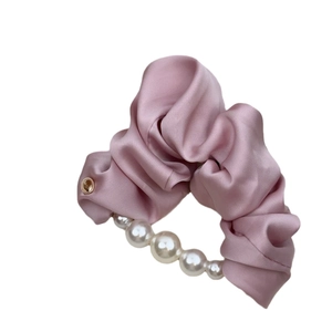 Elegante roze satijnen haarelastiek met grote witte parels en een goudkleurig metaalaccent