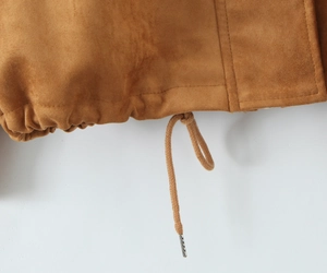 Detail of tan suede jacket hem with adjustable drawstring and metal tips