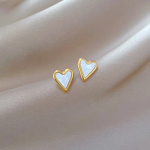 Elegant gold titanium heart stud earrings with white shell inlay on champagne silk fabric