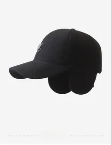 Detail of winter baseball cap with ear flaps and metallic shield logo in black wool