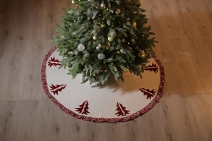 Detailed view of white knitted Christmas tree skirt with red 3D embroidery and tassels