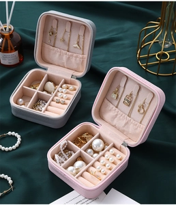 Detail view of pink and grey faux leather jewelry box with interior organizers