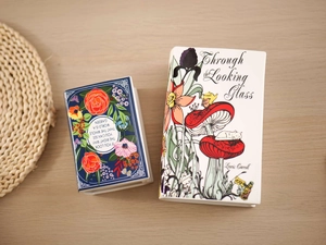 Top view of book-shaped ceramic vases with floral prints and inspirational quotes on a table
