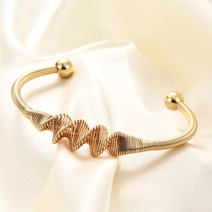 Macro detail of 4mm twisted 18K gold stainless steel bangle with spherical ends