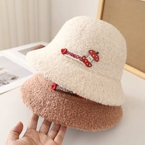 Détail de chapeaux cloches en peluche beige et marron avec broderie et bouton en cœur