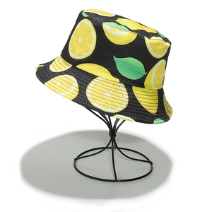 Detailed view of bucket hat featuring vibrant lemon slices print on premium black fabric