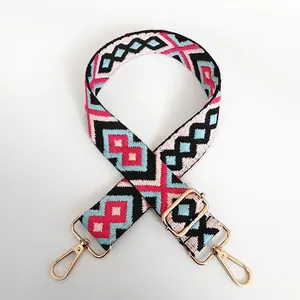 Close-up of diamond pattern jacquard bag strap with golden swivel hooks and buckles