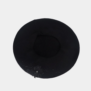 Dettaglio del basco nero in maglia con fiori di pizzo e decorazioni di strass