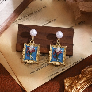 Close-up of vintage French enamel flower earrings with blue petals and white pearls
