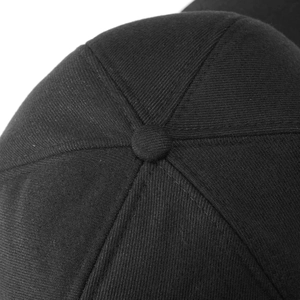 Detail shot of the six-panel crown structure and top button on a black cotton baseball cap